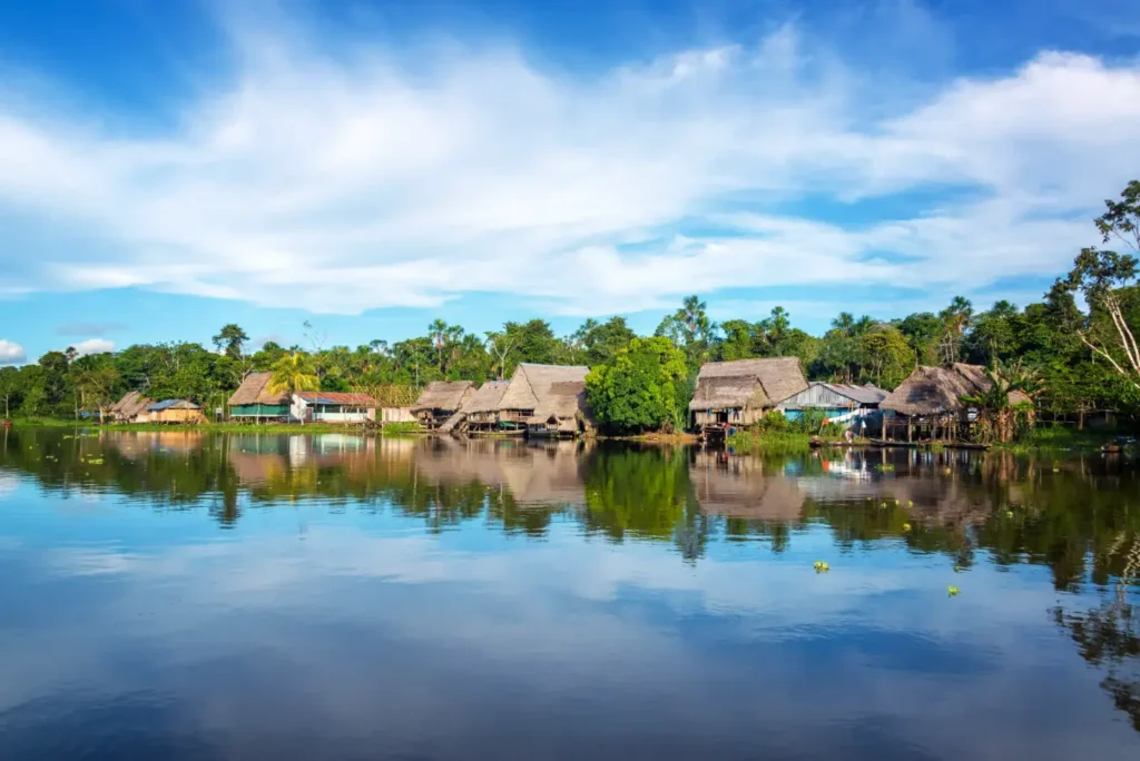 Comunidad ribereña reflejada en un río amazónico