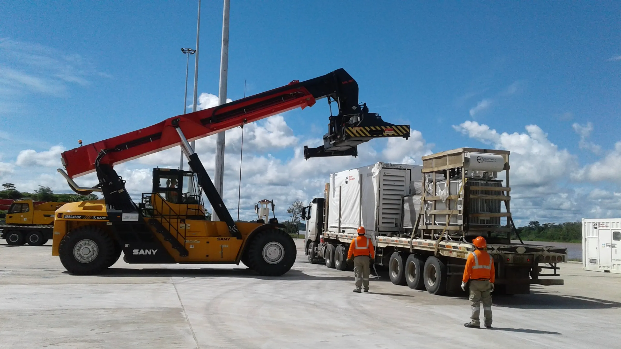 Reach stacker descargando un generador desde un camión en el patio del terminal